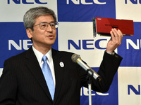 写真1●PCI Express接続のベクトルエンジンを手にする、NECで執行役員常務を務める福田公彦氏