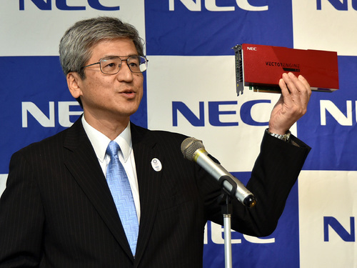 写真1：PCI Express接続のベクトルエンジンを手にする、NECで執行役員常務を務める福田公彦氏