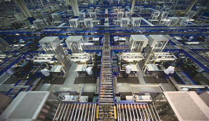 写真1　工場内の全景。サーバーなどを組み立てる従業員を取り巻くように、搬送用のレーンが張り巡らされている