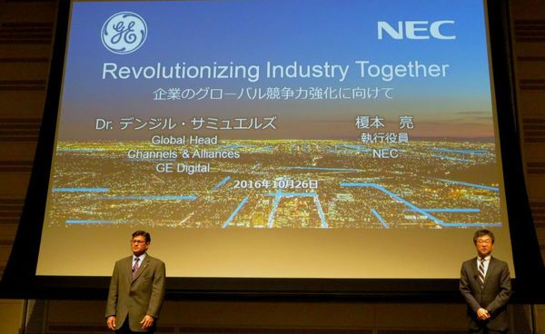 写真2：「Revolutionizing Industry Together」を掲げた提携発表会で話すNEC執行役員の榎本亮氏（右）と、GEのIT・ソフトウェア事業部門であるGE Digitalでチャネル・アライアンス・ビジネス開発ベンチャー担当グローバル責任者を務めるデンジル・サミュエルズ氏