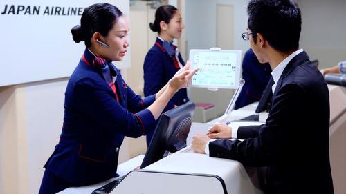 写真1：本サービスシステムを利用したチェックインカウンター業務の様子（出典：日本航空）